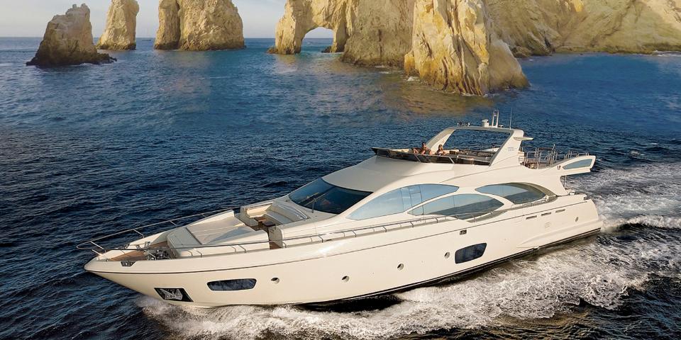 Azimut motor yacht underway in front of the granite rocks of Land's End