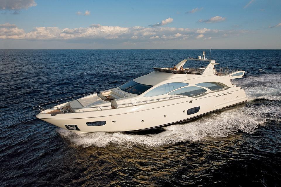 White Azimut motor yacht cruising at speed on blue water