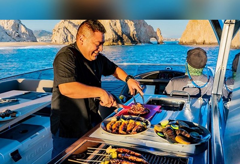 Chef preparing seafood on the grill aboard a yacht
