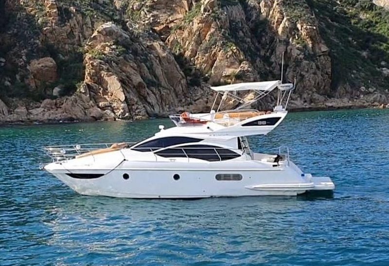 40-foot Azimut flybridge yacht cruising past the rocky Cabo coastline