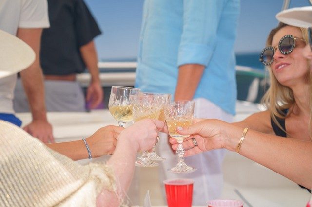 Guests raising glasses for a toast on board a yacht