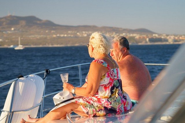 Couple enjoying a drink on the bow of a yacht in the late afternoon