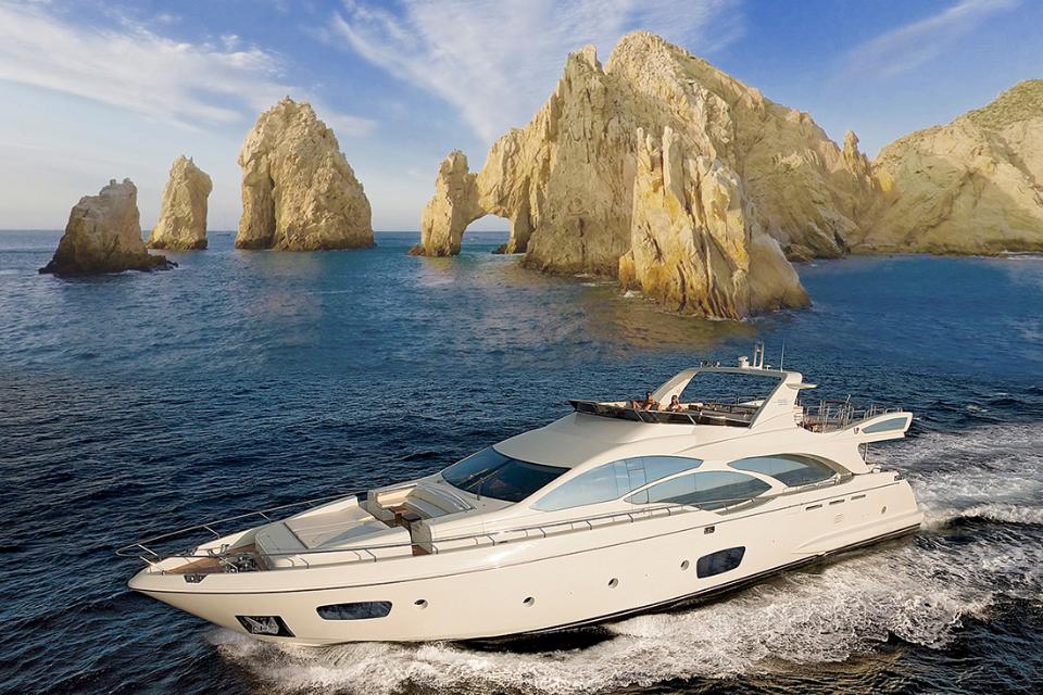 Motor yacht cruising past the rock formations of Land's End in Cabo San Lucas